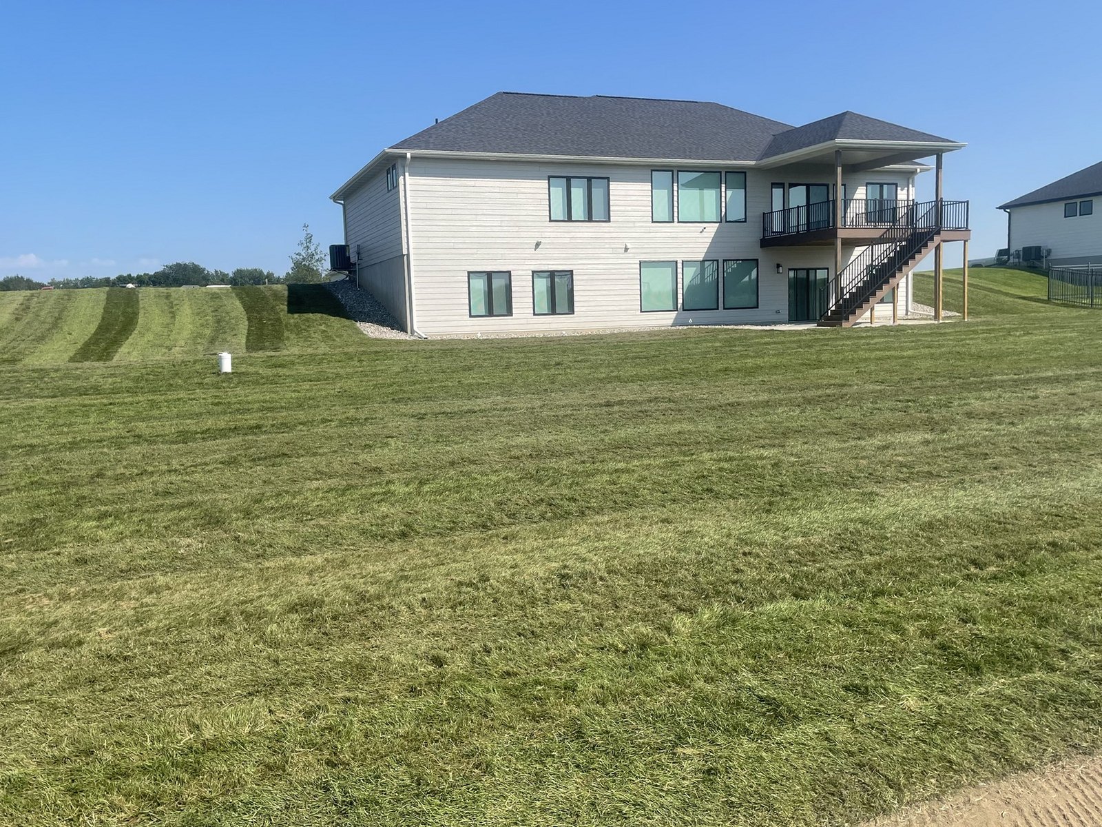 The same home with the slope fully sodded and mowed after installation